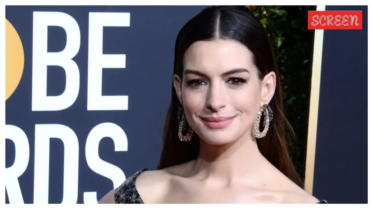 Anne Hathaway smiling during a high-fashion interview with soft lighting.