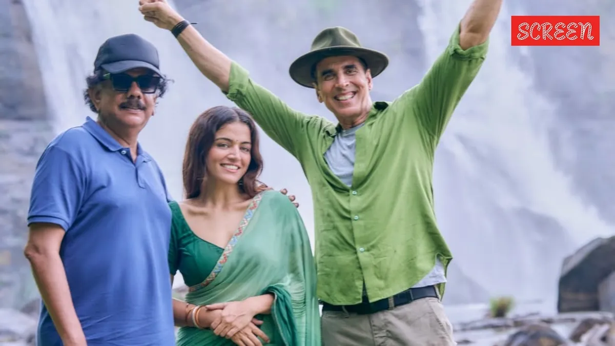 Akshay Kumar posing for a movie poster with a spooky background