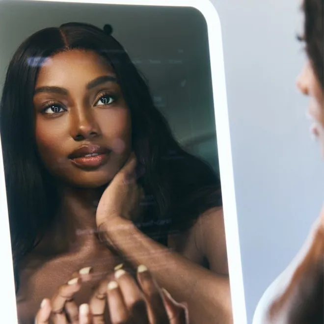 A person looking into a sleek, modern smart mirror.
