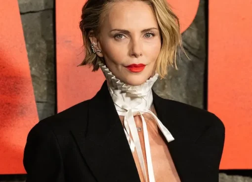 Charlize Theron smiling while talking about her daughter August