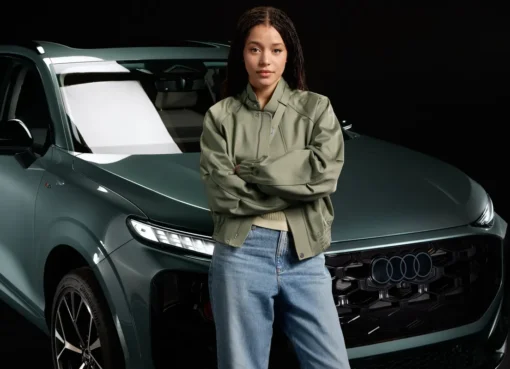 Chase Infiniti smiling, perhaps alongside a sleek Audi car.