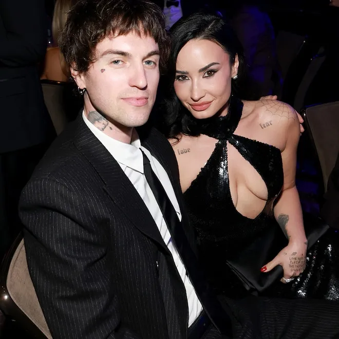 Demi Lovato and Jutes holding hands and singing together on a softly lit stage during a concert in New York City.