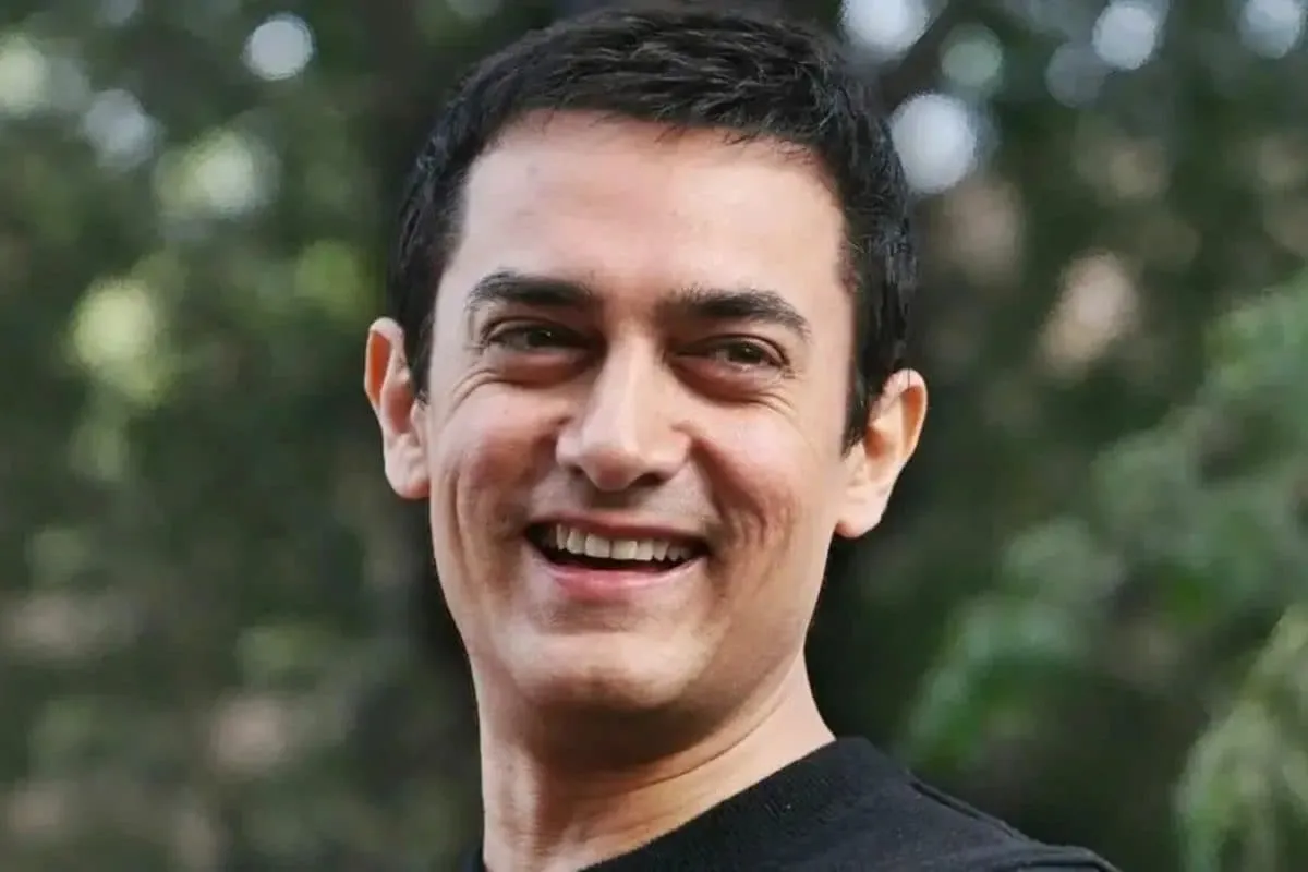 Aamir Khan and Deven Bhojani smiling during a movie scene