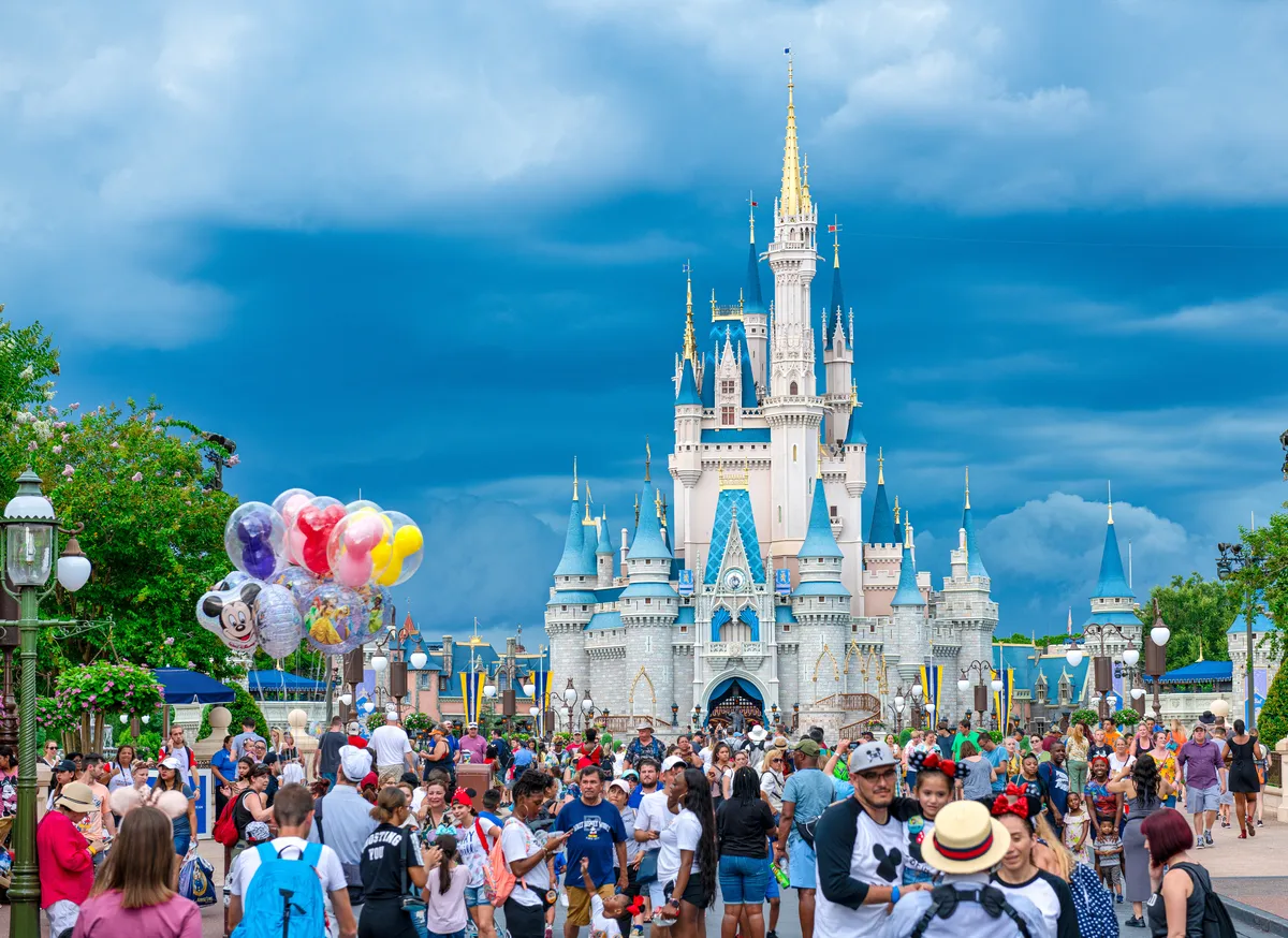 The colorful Cinderella Castle at Disney World under a bright blue sky