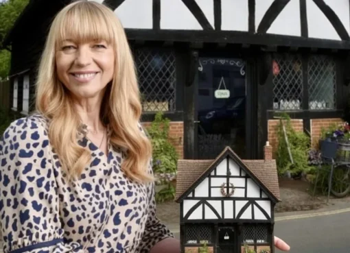 A person's hands carefully placing a tiny detail on a miniature building.