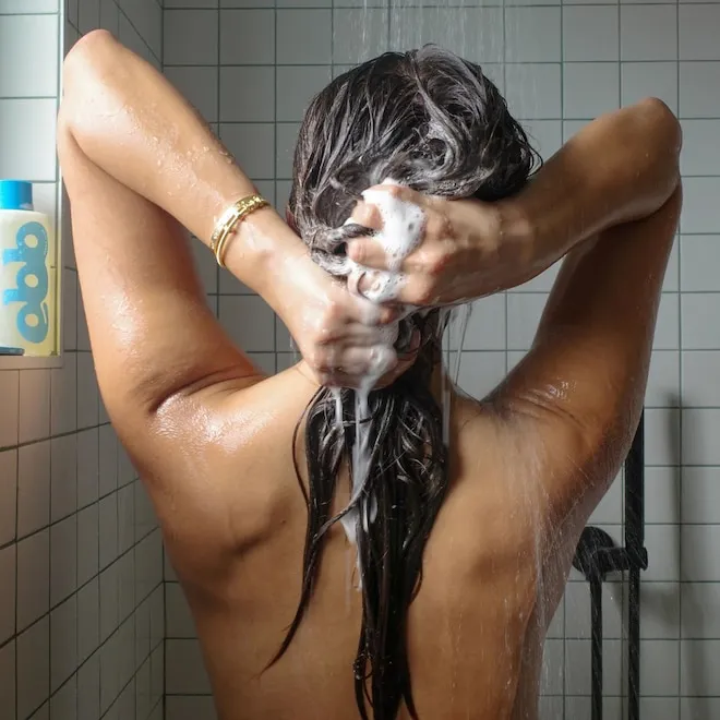 A close-up of shiny, healthy hair with a bokeh background of Sephora products.