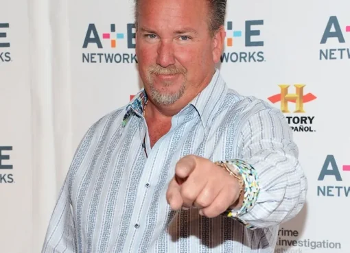 Darrell Sheets smiling and looking at a storage unit on the set of Storage Wars.