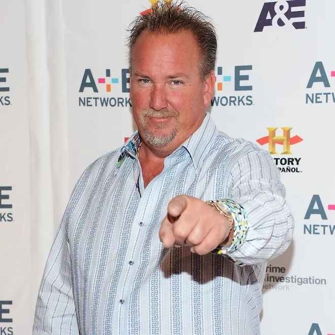 Darrell Sheets smiling and looking at a storage unit on the set of Storage Wars.