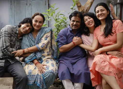 Actor-filmmaker Anshuman Jha smiling, possibly at a film festival, with a vibrant film reel graphic in the background.