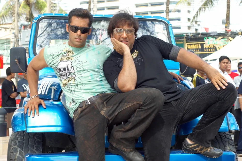 A collage of movie posters from David Dhawan's comedy films.