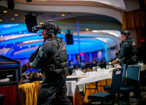 Chaos erupts in a lavish ballroom, with Secret Service agents quickly rushing President Trump away as people duck for cover and journalists pull out their phones.