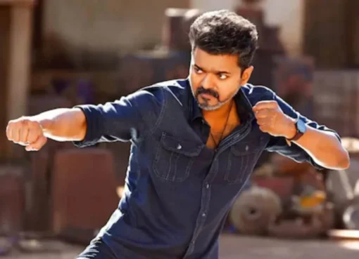 Thalapathy Vijay looking intense on a movie set with professional lighting equipment.