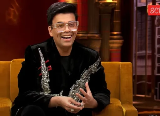 Karan Johar smiling on the Koffee With Karan couch.