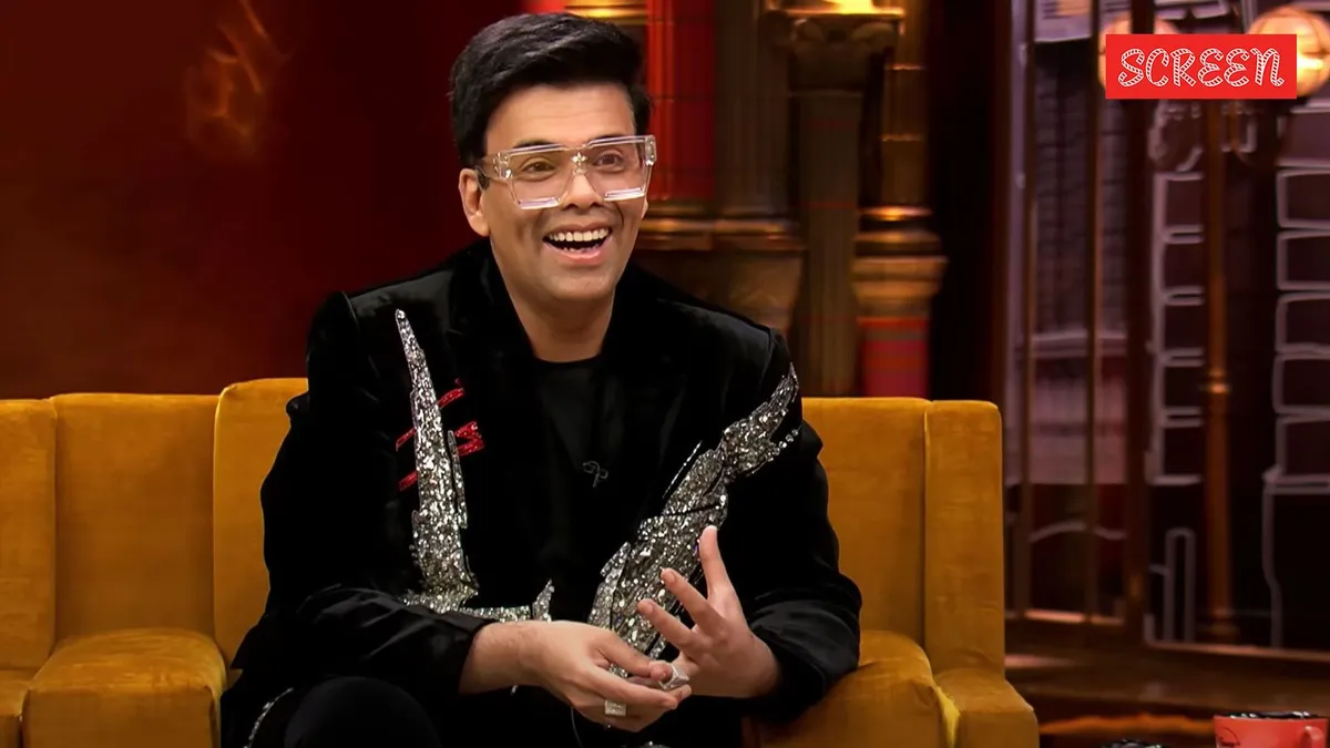Karan Johar smiling on the Koffee With Karan couch.