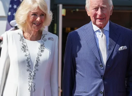 King Charles III and Queen Camilla waving upon arrival.
