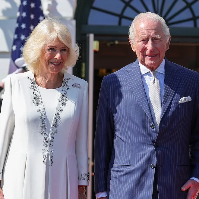 King Charles III and Queen Camilla waving upon arrival.