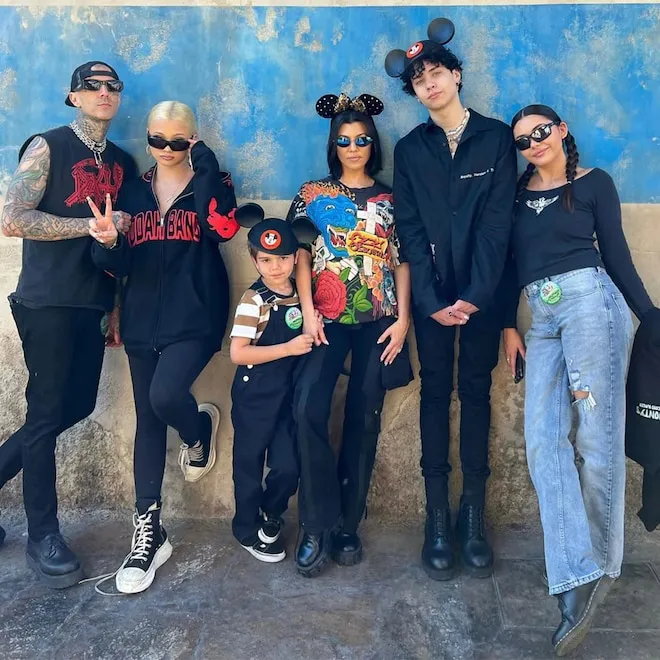 Kourtney Kardashian and Travis Barker with their blended family, smiling.