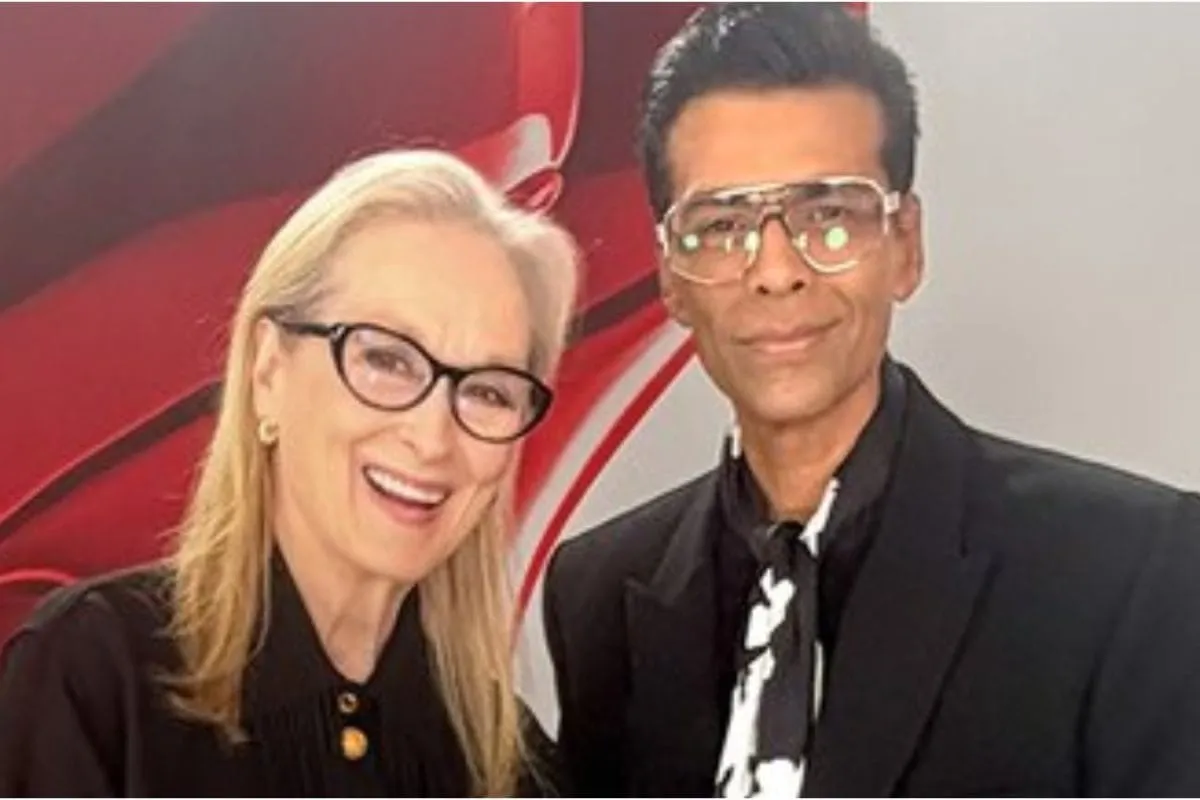 Meryl Streep and Karan Johar interacting, with Meryl Streep looking at his footwear.