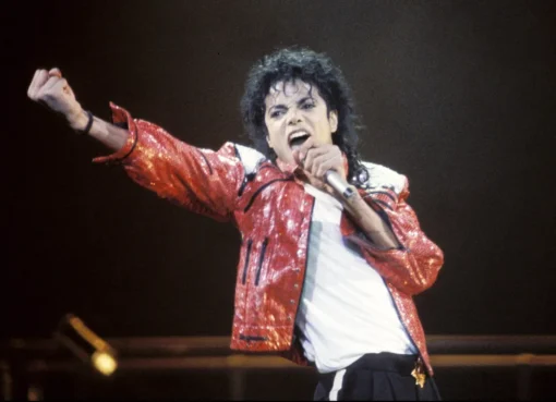 A dramatic close-up of Michael Jackson in his prime, with a fierce, focused expression.