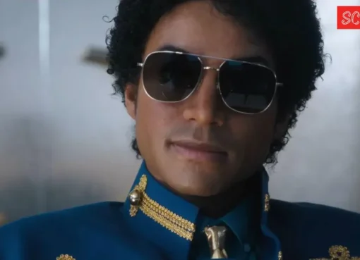 A performer on stage mimicking Michael Jackson's iconic dance pose in a gold jacket.