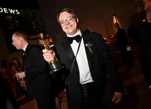 A golden Oscar statue with an airport security tag attached to its base.