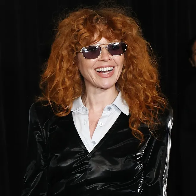 Natasha Lyonne with her signature curly red hair looking stylish.