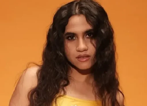 Nikhita Gandhi singing informally in a college corridor surrounded by students after a power outage.