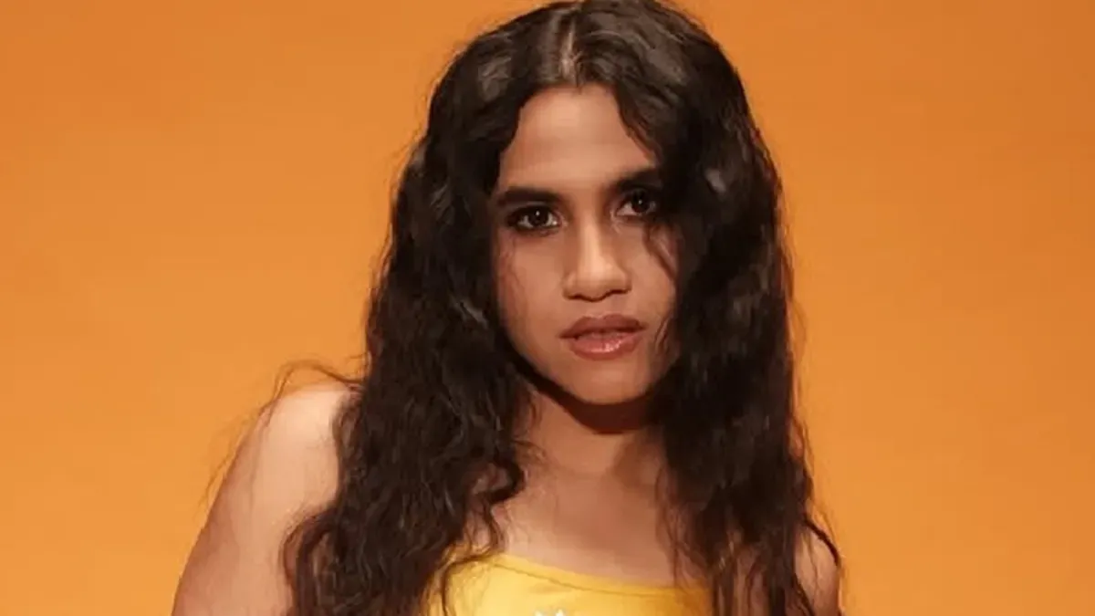 Nikhita Gandhi singing informally in a college corridor surrounded by students after a power outage.