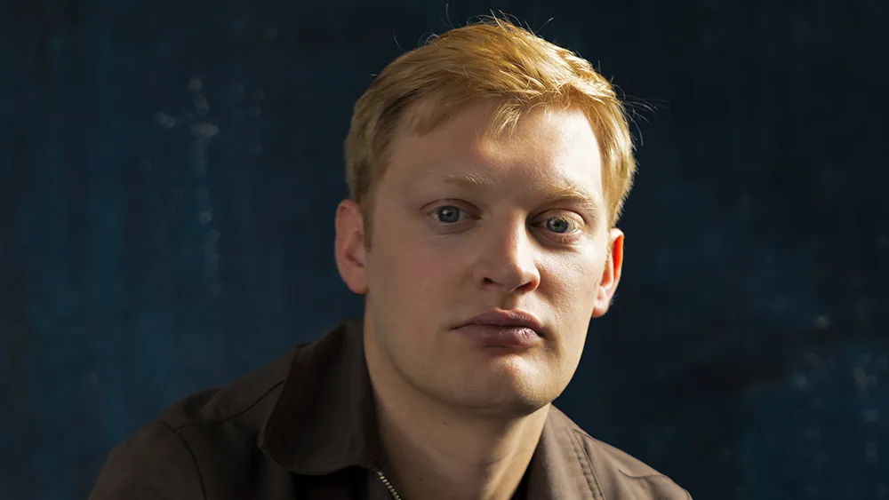 A stylized image featuring a silhouette of a person holding a chainsaw, with a moody, dark background, hinting at the horror film 'The Texas Chainsaw Massacre' reimagining.