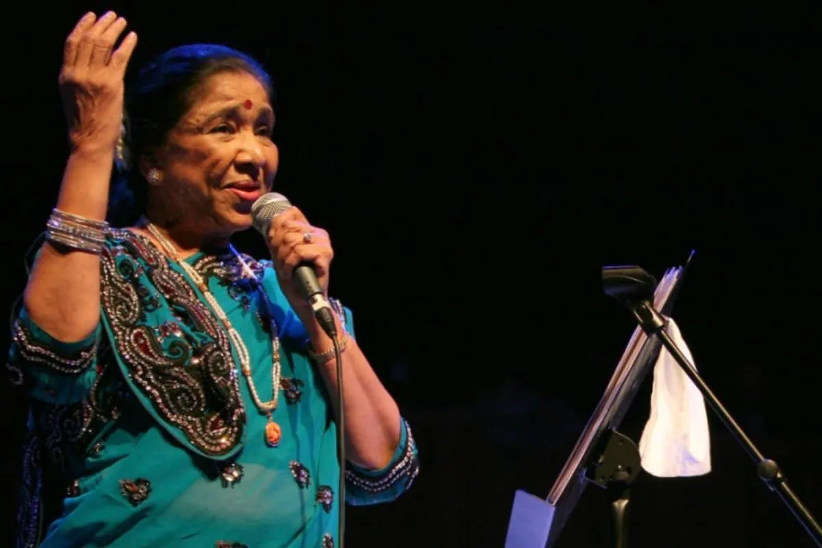 A vibrant, close-up photo of Asha Bhosle singing with passion.