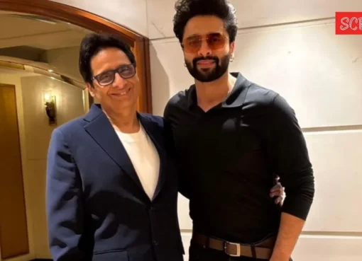 Vashu Bhagnani standing in a busy street market with sarees.