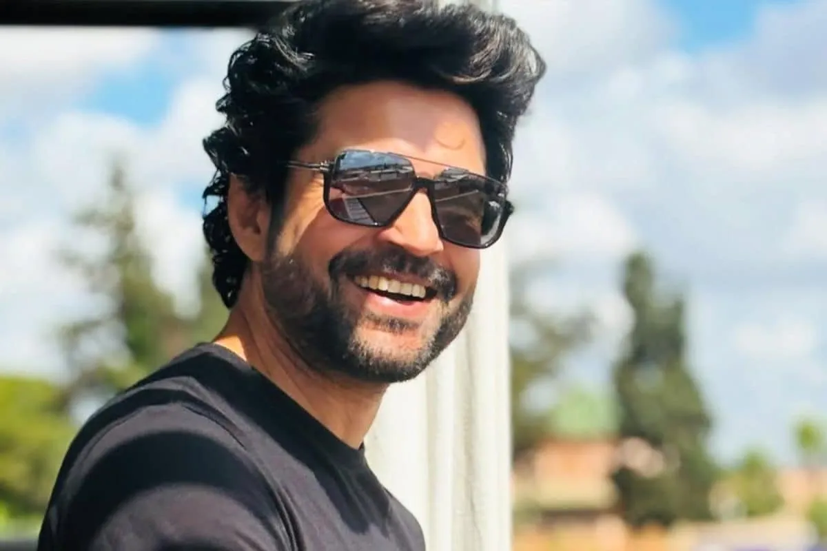 Rajeev Khandelwal in a thoughtful pose, smiling slightly.