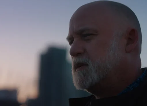 A still image from a film trailer showing a person looking determined.