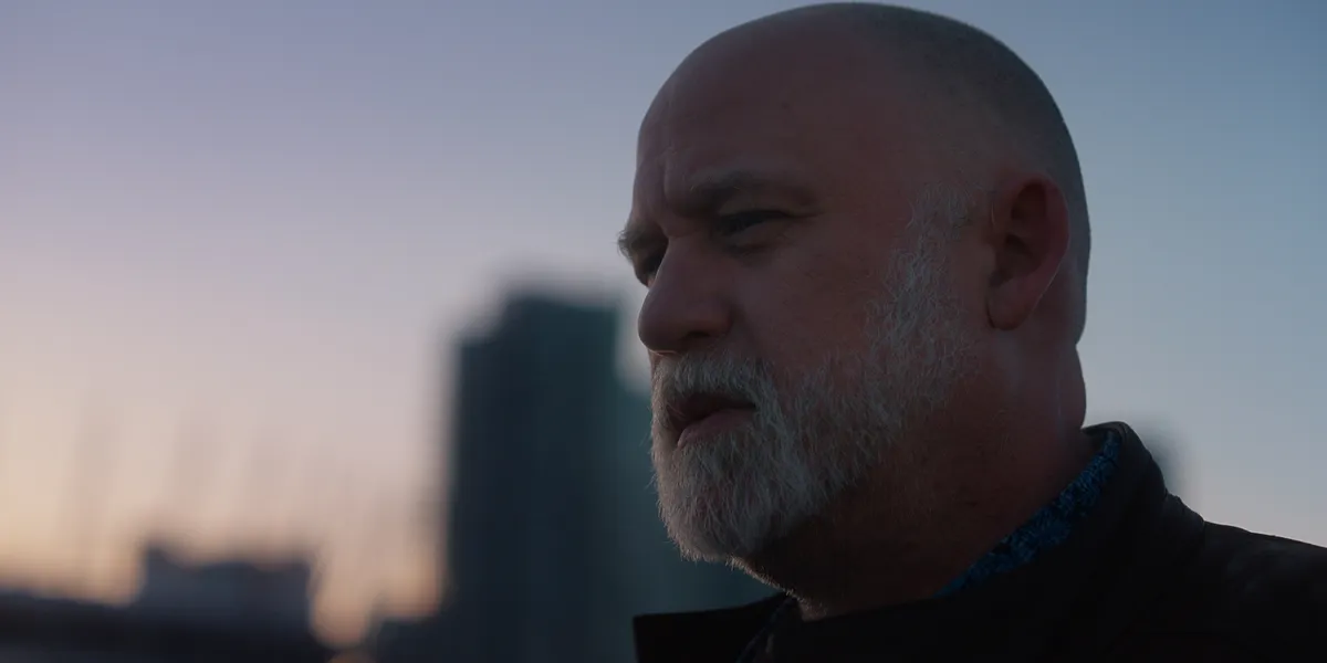 A still image from a film trailer showing a person looking determined.