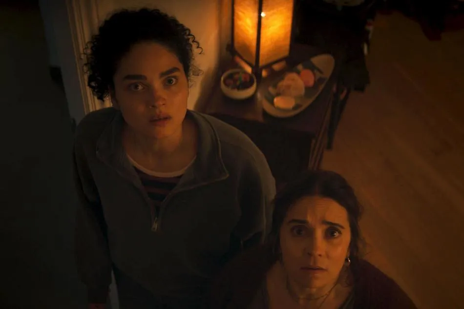 A dark, eerie still from the horror movie 'Monitor', showing a distorted face on a screen glowing with blue light.