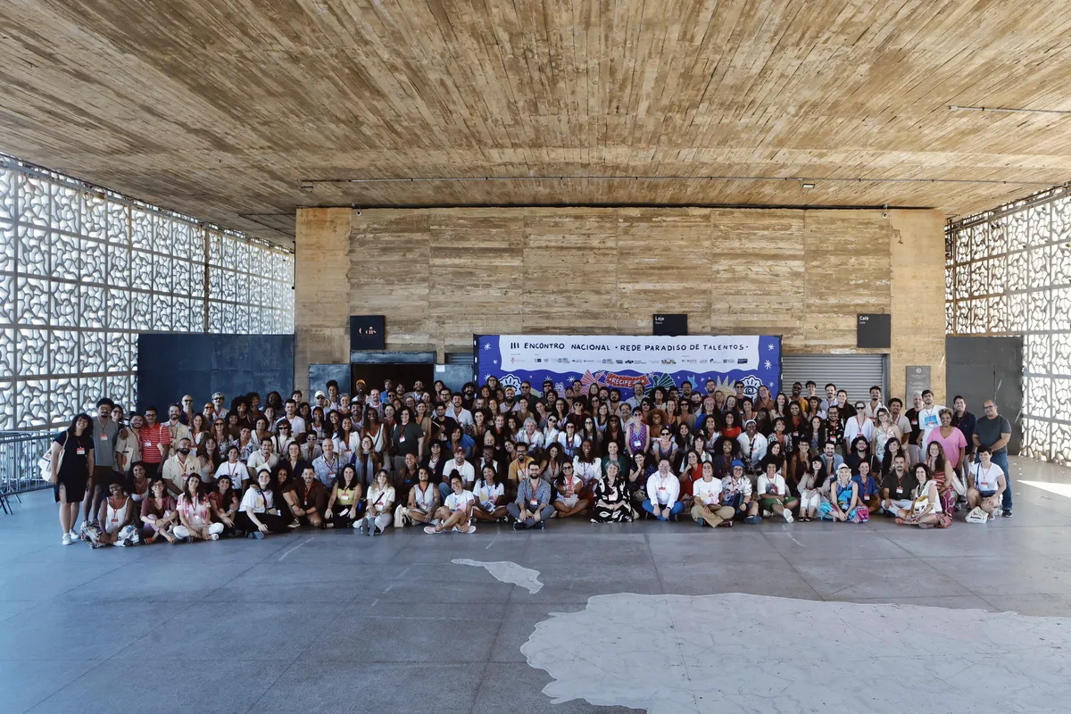 A diverse group of filmmakers smiling and talking, actively collaborating in a bright, modern meeting space.
