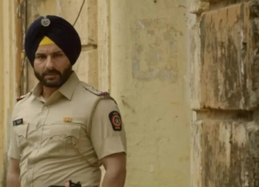 Saif Ali Khan in a cop uniform, looking serious.