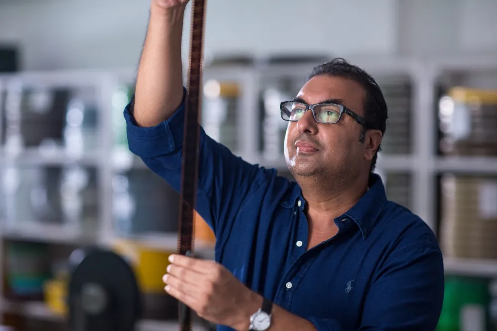 Shivendra Singh Dungarpur looking focused while holding an old film reel.