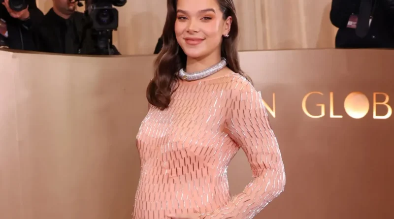 Hailee Steinfeld and Josh Allen smiling, holding their newborn baby girl.