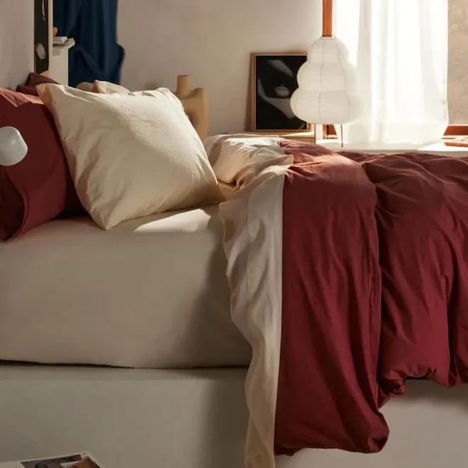 A neatly made bed with organic cotton sheets.