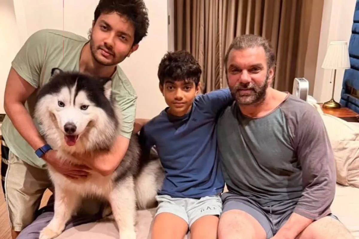 Sohail Khan smiling happily with his two sons, Nirvaan and Yohan, and a pet husky.