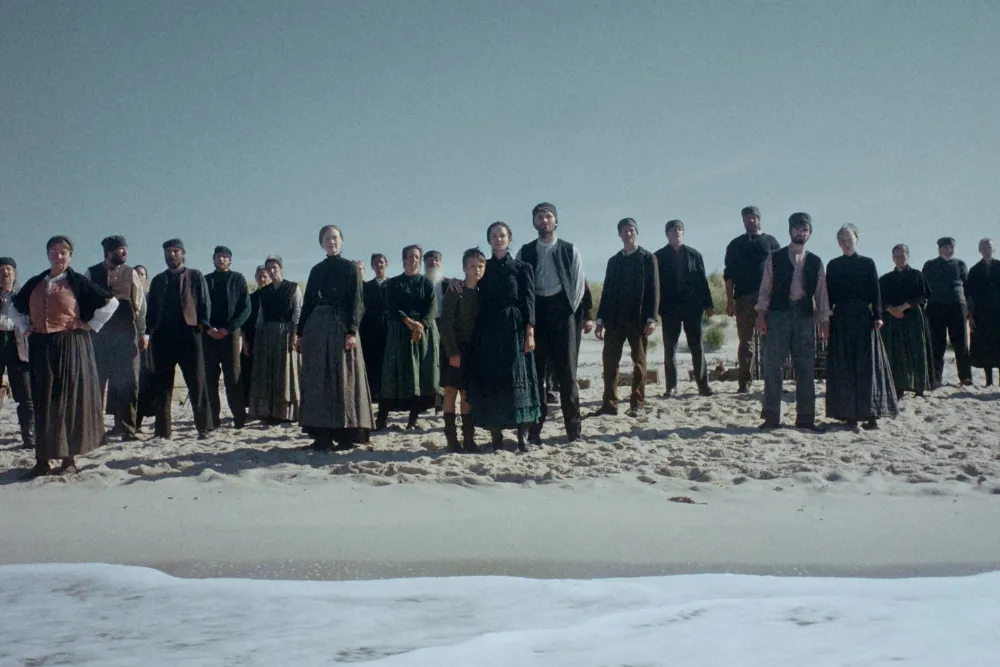 Still from 'Trial of Hein' showing a gaunt young man, Paul Boche as Hein, arriving by boat at a misty, isolated fishing village.