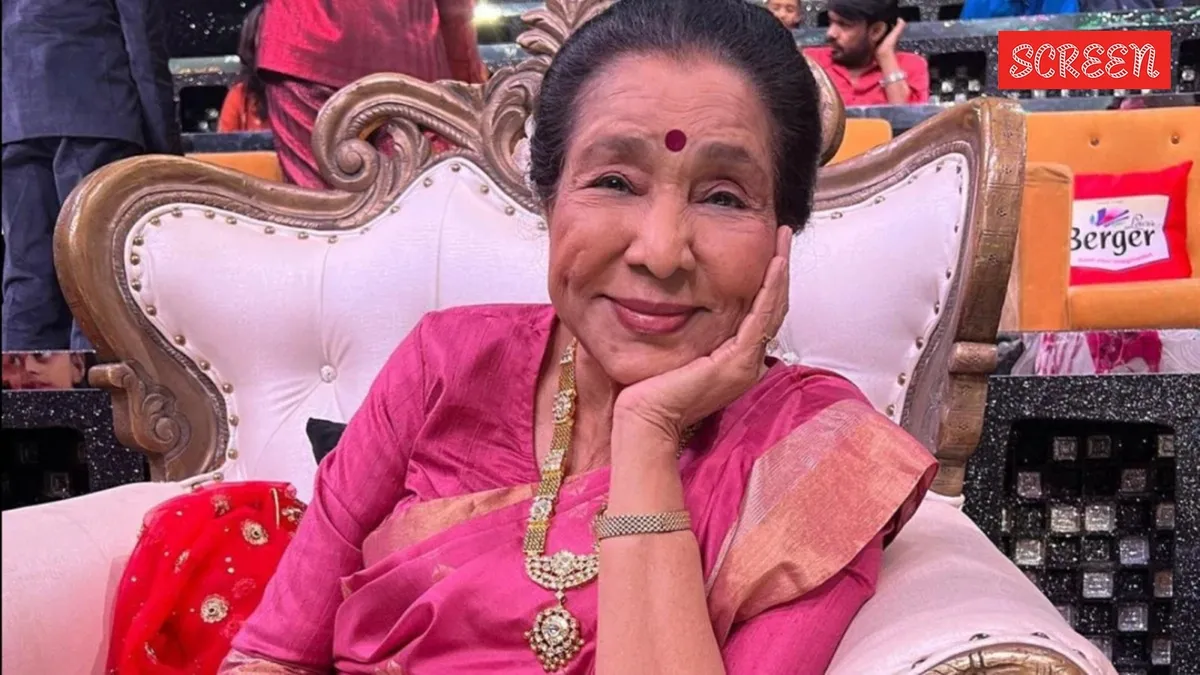 Close-up portrait of a smiling Asha Bhosle.