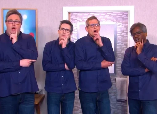 A still image from a comedy sketch showing multiple actors dressed as Louis Theroux in a hotel room.