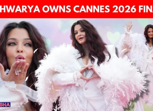 Aishwarya Rai Bachchan striking a pose in a dramatic all-white pantsuit with a feathered boa at the Cannes 2026 closing ceremony.