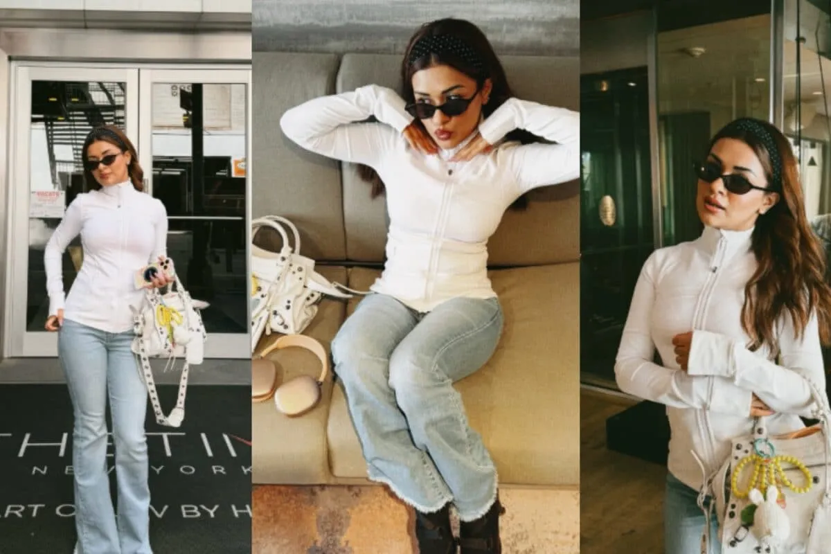Avneet Kaur in a white top and light bootcut jeans, carrying an oversized white handbag with charms in New York City.