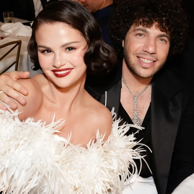 Selena Gomez and Benny Blanco laughing together at a table.