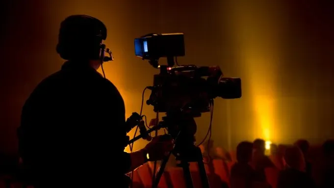 An illustration of a bright helpline icon with a film clapperboard and TV screen, symbolizing a new era of safety for the creative industries.