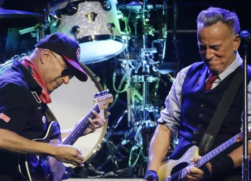 Bruce Springsteen and Tom Morello on stage with guitars.