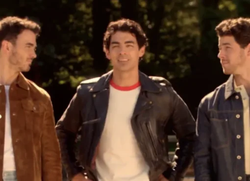 The Jonas Brothers smiling and holding guitars